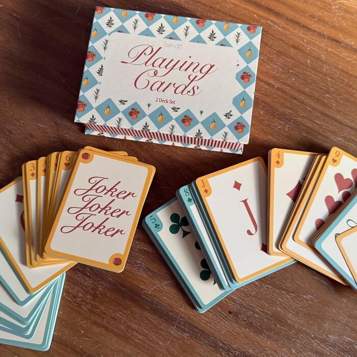 Bando playing cards set displayed on a wooden table, featuring colorful design with Joker card visible.