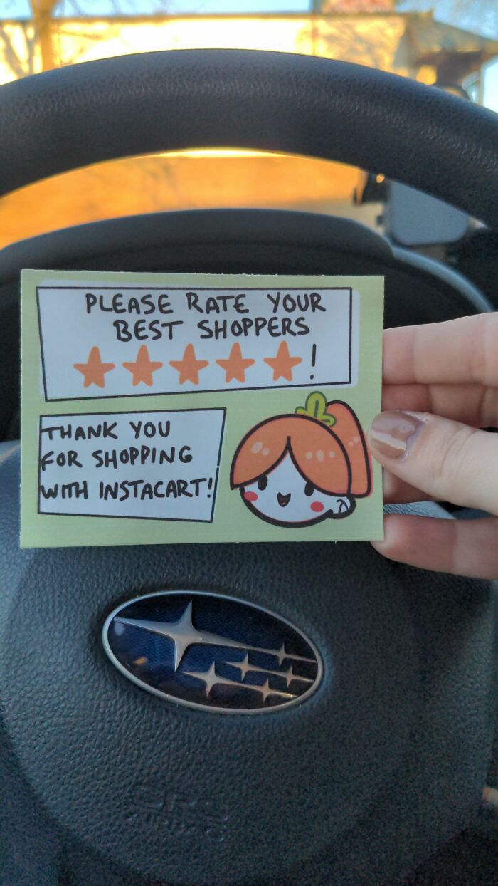 Instacart shopper thank you card with cartoon, five-star request, held in front of a car steering wheel.