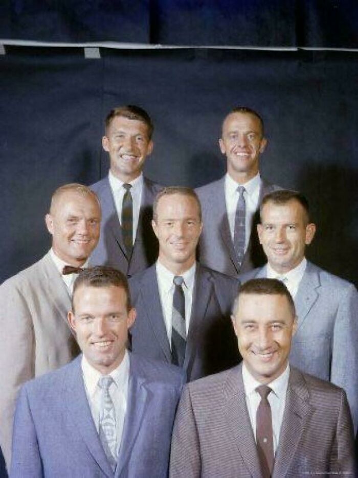 Seven men in suits smiling in a rare historical group photo.