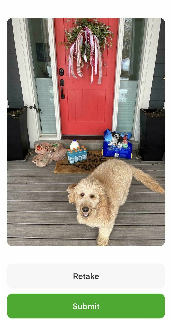 Instacart delivery with a dog sitting on the porch, items left by a red door with a decorative wreath.