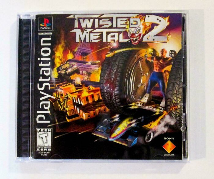 PS1 game cover of Twisted Metal 2, featuring a clown and vehicles in flames, celebrating the '90s gaming era.