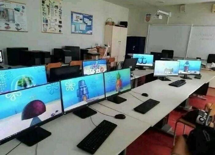 Computer lab setup with multiple monitors all displaying different SpongeBob-themed wallpapers, showing the weird side of the internet.