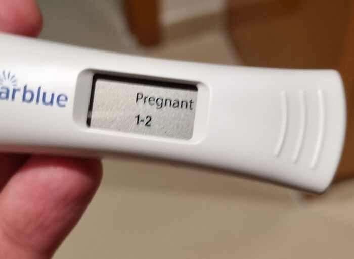 Close-up of a positive pregnancy test held by hand, symbolizing new parenting moments for dads.