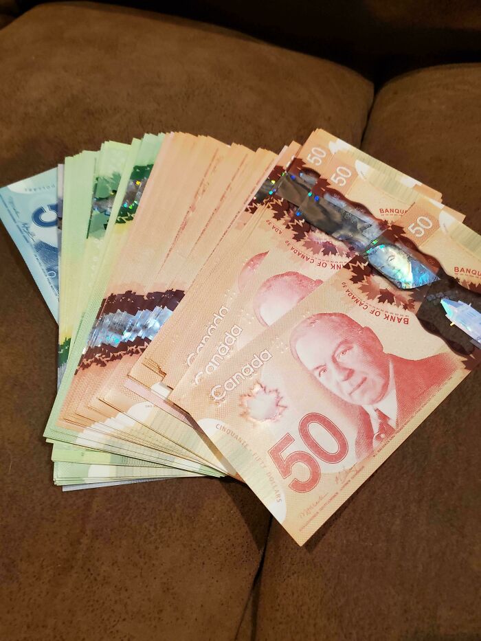 Stacks of Canadian dollar bills found while thrifting, showcasing a lucky find and thrifting success.