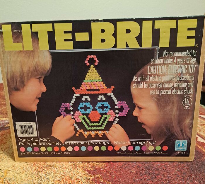 Children playing with Lite-Brite toy box featuring a colorful clown face design, evoking a sense of nostalgia.