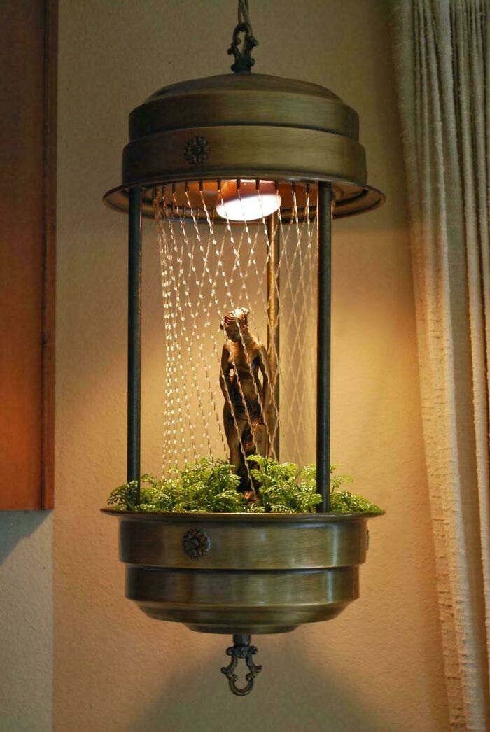 A retro waterfall lamp with plants and a faux tree inside, evoking nostalgia.