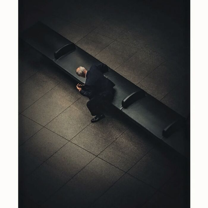 Minimalist shot of a person sitting alone on a bench, capturing a quiet side of Tokyo.