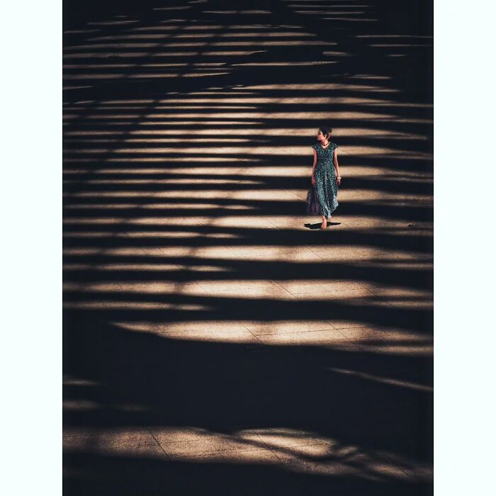 Person walking in shadows, showcasing a quiet, hidden side of Tokyo through minimalist photography.