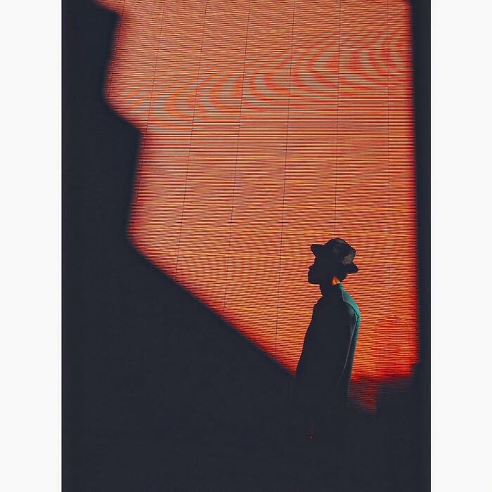 Minimalist shot of a silhouette against a textured orange background, capturing the hidden side of Tokyo.