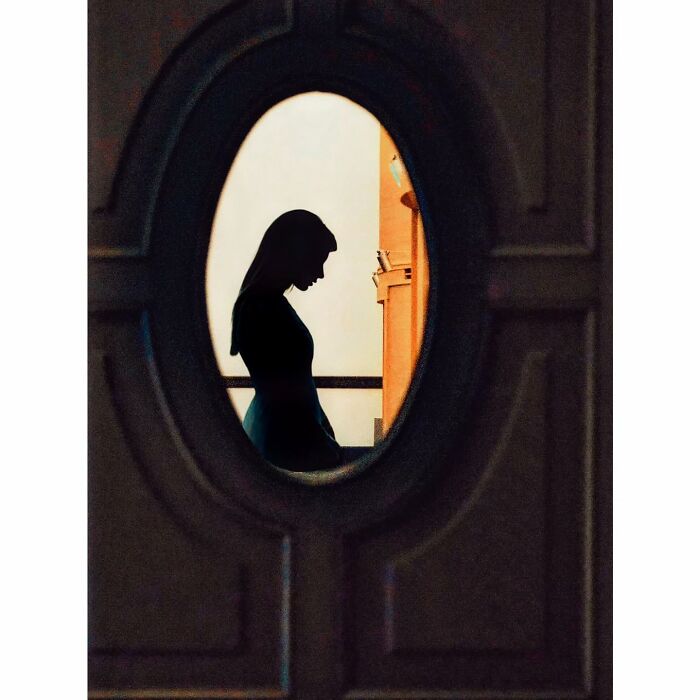 Silhouette of a woman through an oval window, depicting a hidden side of Tokyo in a minimalist style.
