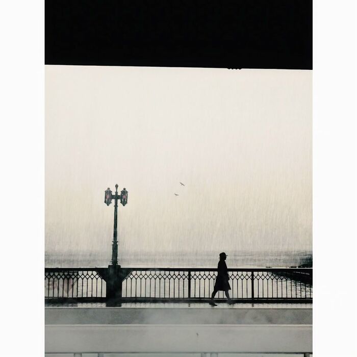Minimalist photo of a person walking on a bridge in Tokyo, emphasizing a quiet and hidden side of the city.