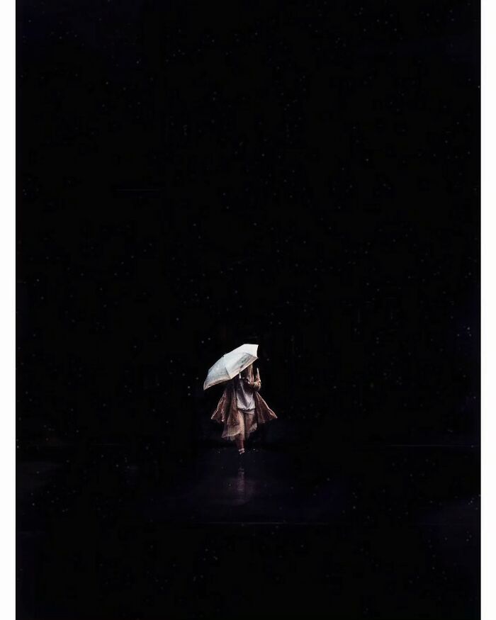 A lone figure under an umbrella in a minimalist, hidden side of Tokyo.