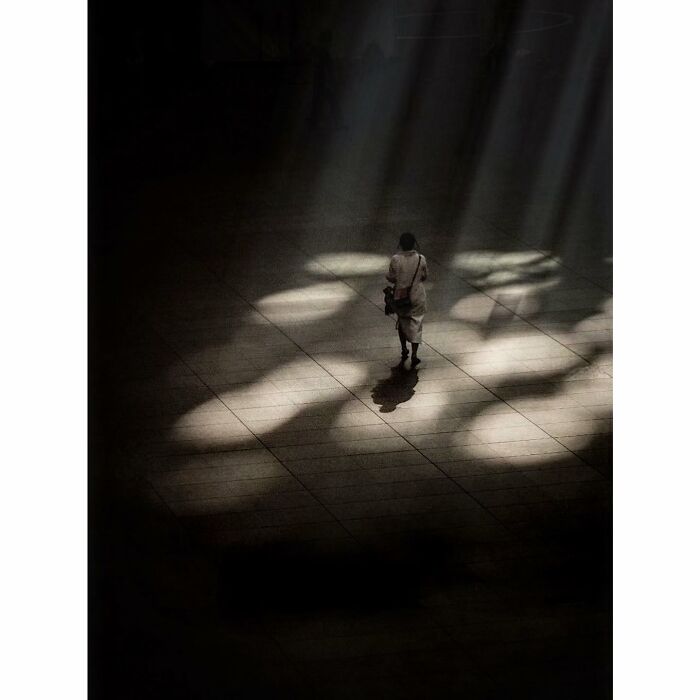 A lone figure walks through a softly lit area in Tokyo, highlighting its quiet, hidden side in a minimalist scene.