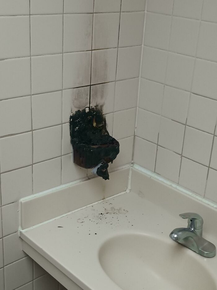 Burned wall outlet in a bathroom with soot stains; a mildly interesting discovery.