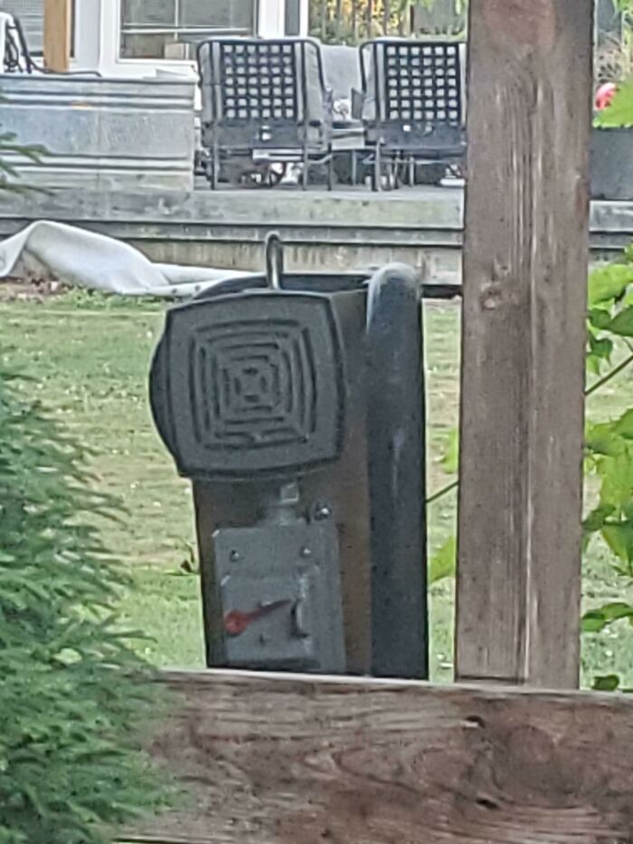Outdoor speaker mounted on a fence in a backyard setting, possibly illustrating noise issues with neighbors.