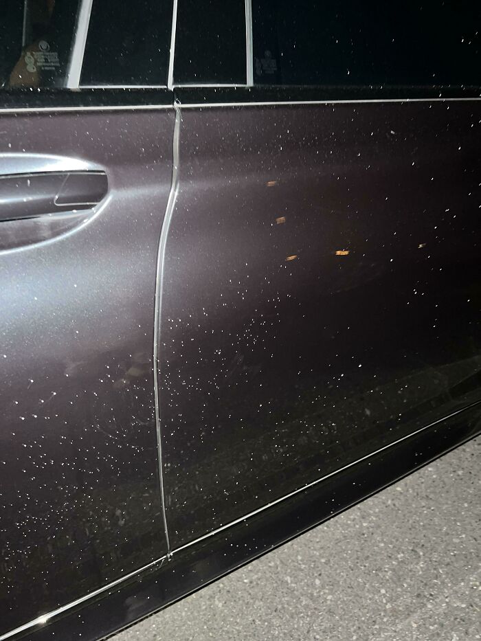 Scratched car door, possible result of terrible neighbors' mischief.