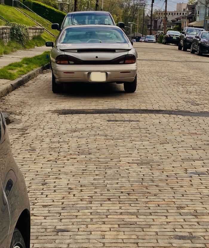 Parked car blocking driveway, a classic terrible neighbor move.
