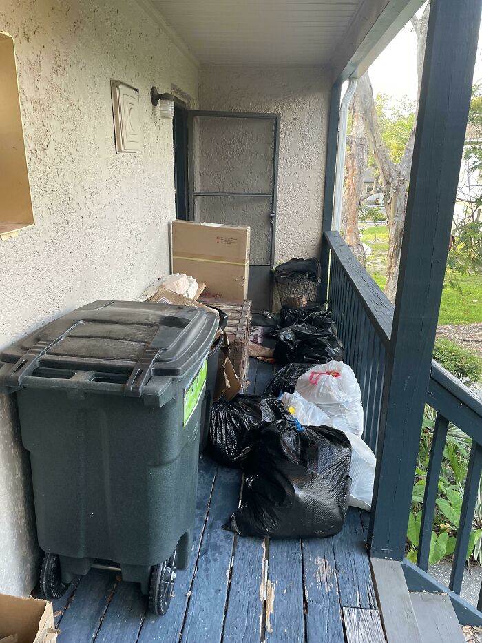 Porch cluttered with garbage bags and trash bins showing horrific neighbor behavior shamed by others in the community.