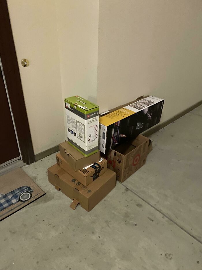 Stack of delivery boxes left in a hallway, representing terrible neighbors' disregard for shared spaces.
