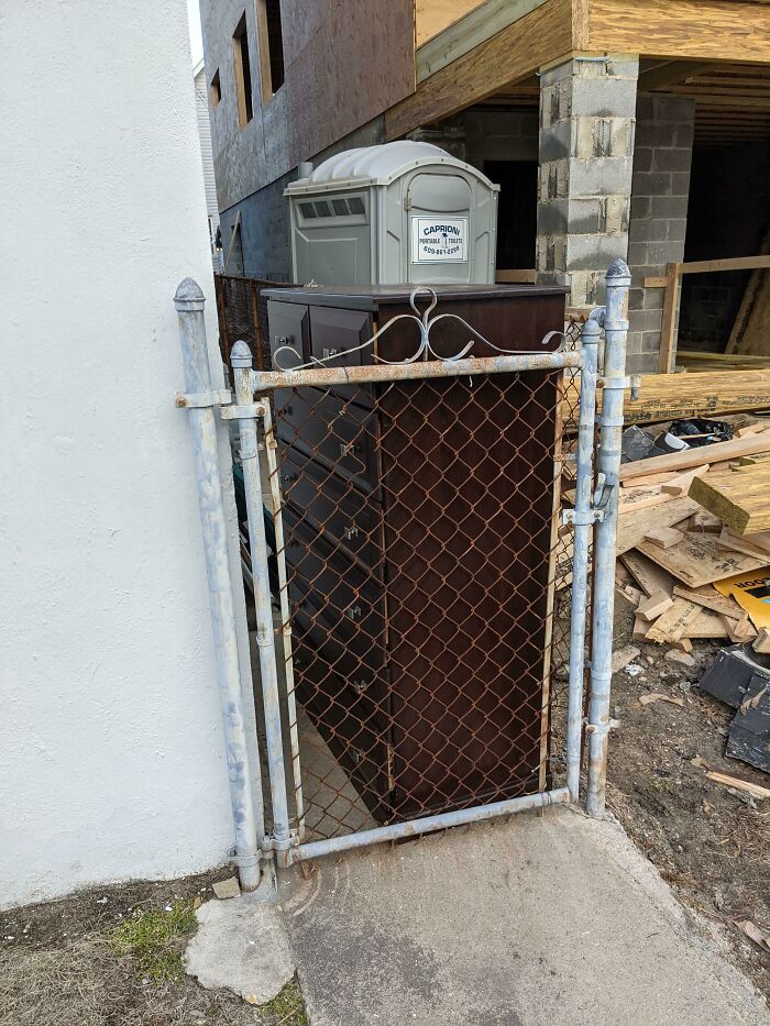 Blocked gate by furniture and portable toilet, illustrating terrible neighbors.