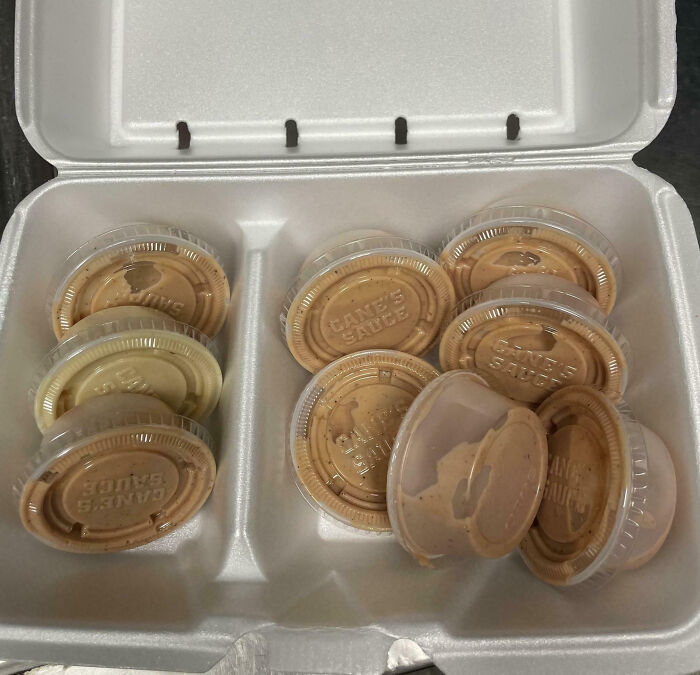 Takeout container full of sauce cups, highlighting food scams with excessive packaging.