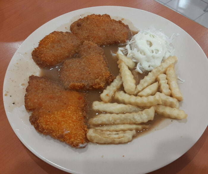 Plate of breaded chicken, soggy fries, and coleslaw; an example of infuriating food scams.