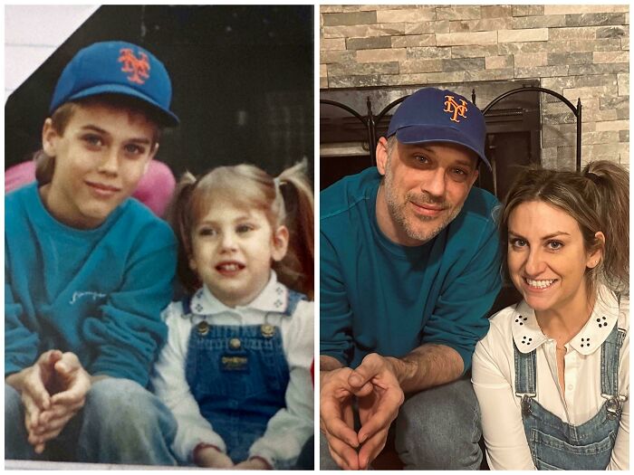 Two people recreate a past photo wearing similar outfits, including a blue Mets cap and denim overalls, in front of a fireplace.