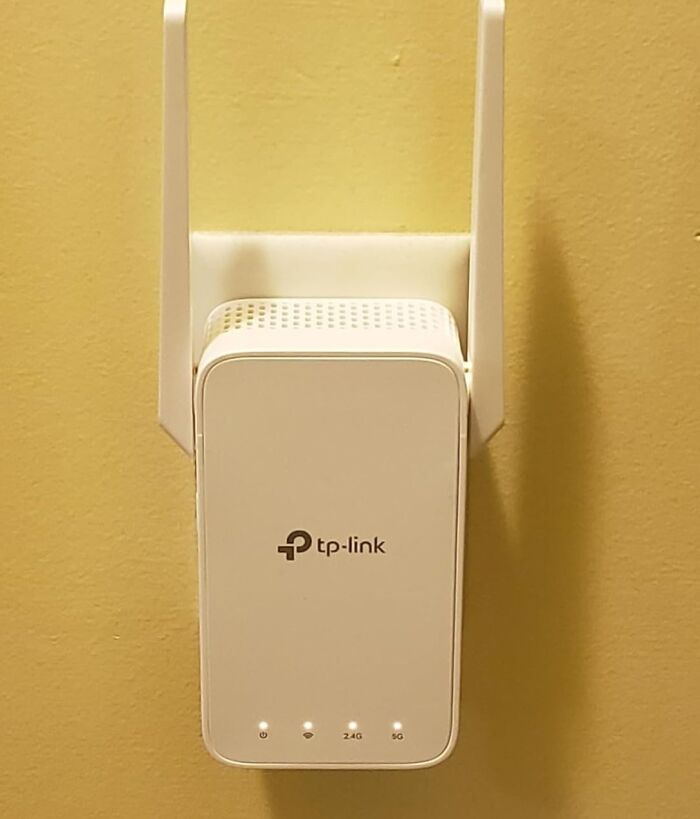 Wi-Fi extender plugged into a wall, a key work from home tech essential for better connectivity.