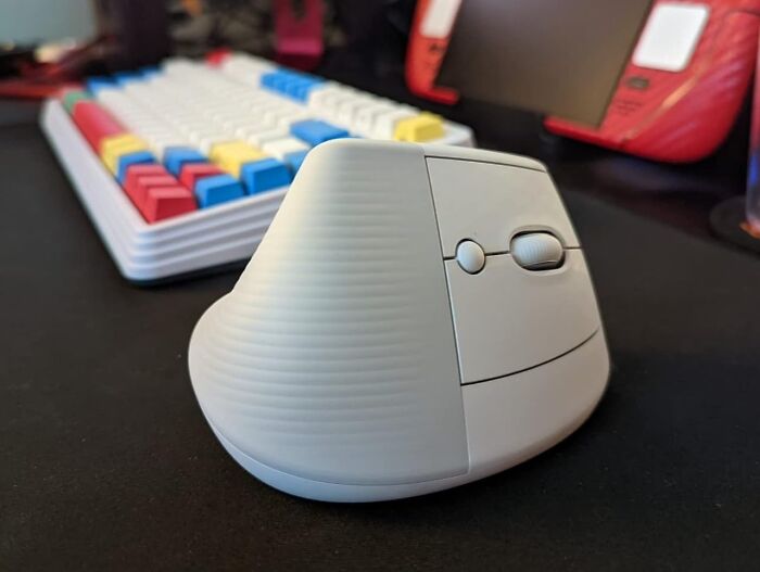 Vertical mouse and colorful keyboard on a desk, highlighting essential work from home tech.