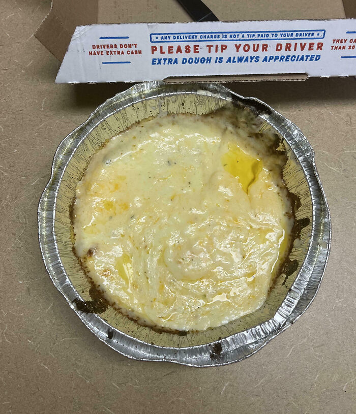 Melted cheese in a foil container, possibly showcasing infuriating food scams.