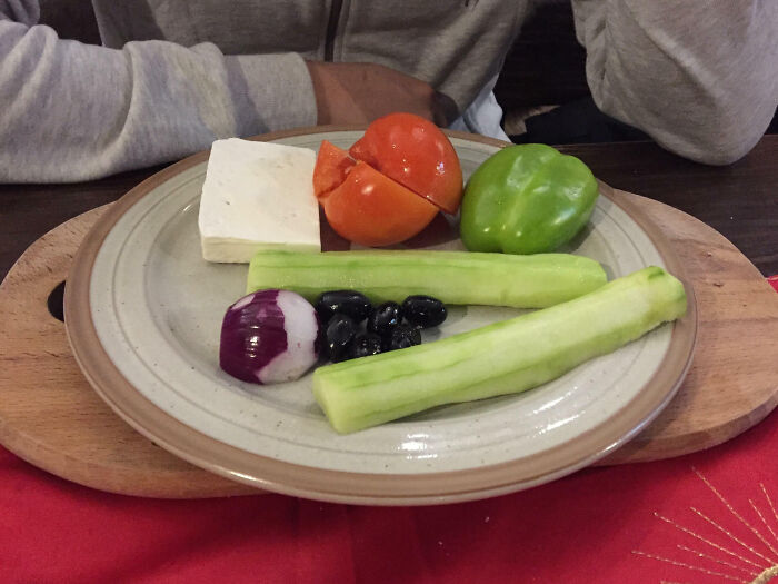 Plate with minimal vegetables and cheese, representing infuriating food scams.