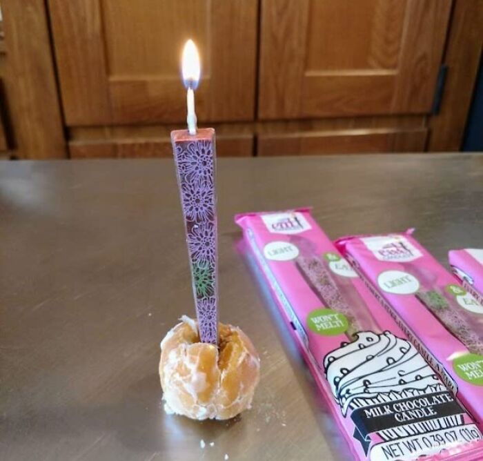 Milk chocolate candle in a holder, displayed on a table with packaging, highlighting Sharktank items.