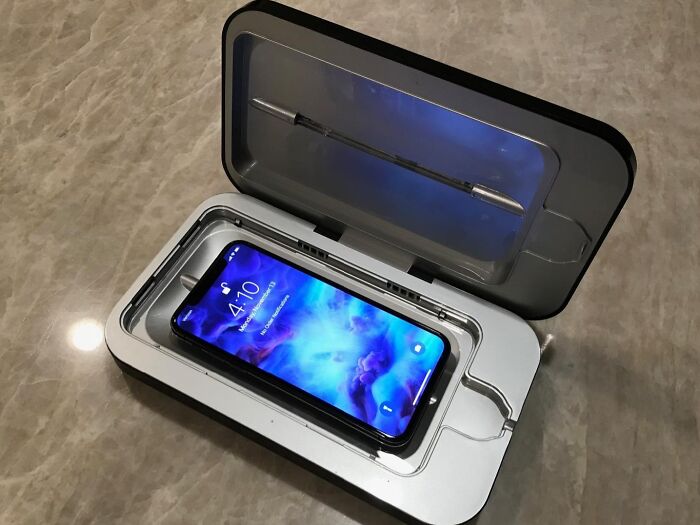 UV phone sanitizing device, a popular Sharktank item, on a marble surface, with a smartphone inside the open case.