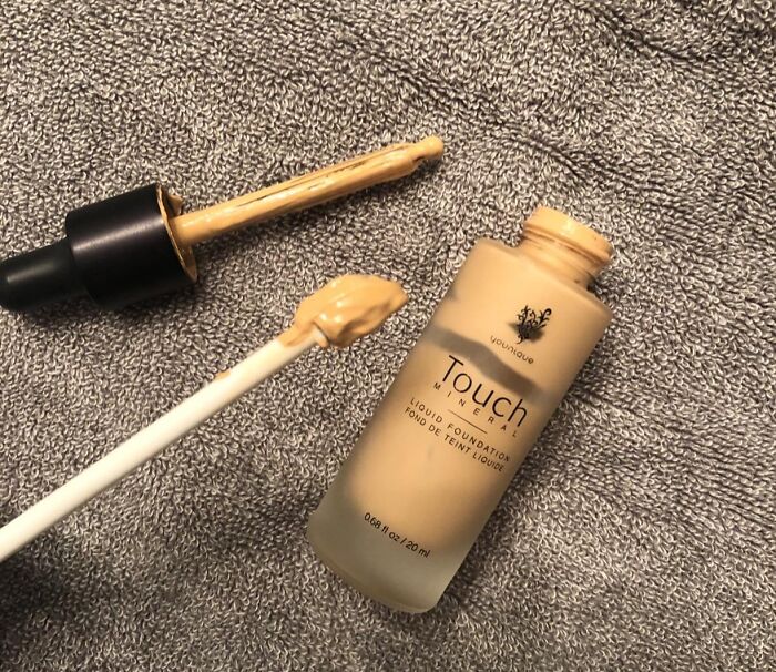 Liquid foundation with dropper on grey towel, a Sharktank favorite product.