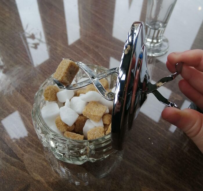 Cool-old-things: Vintage sugar cube dispenser being opened by a hand, filled with white and brown sugar cubes.