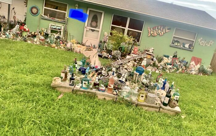 Front yard in Florida adorned with eclectic decor and figures, showcasing unique wild moments and creativity.