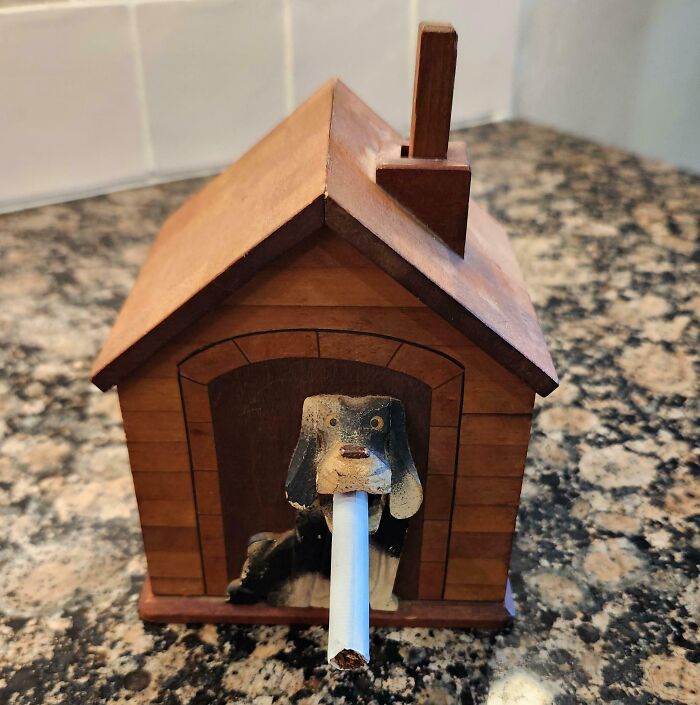 A vintage wooden doghouse cigarette dispenser showcasing cool old things.