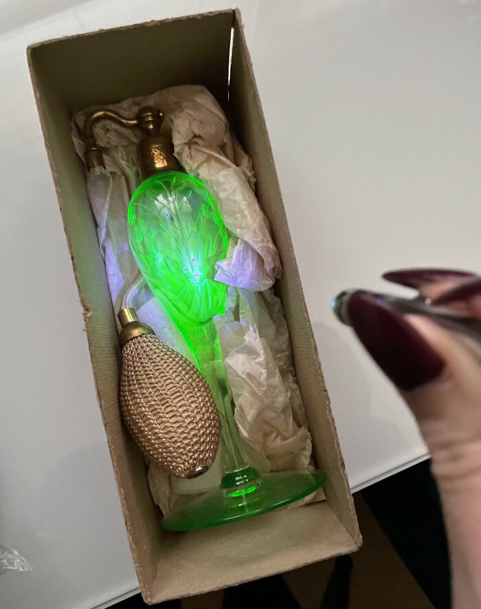 Vintage green glass perfume bottle glowing in a box, with pump attached, showcasing cool-old-things.