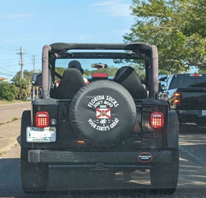 Jeep on a Florida road with humorous text on the spare tire cover.