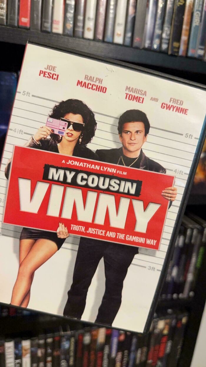 '90s film poster of My Cousin Vinny with characters holding a sign against a height chart backdrop.