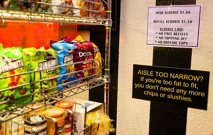 Snack display with humorous sign about narrow aisle in a convenience store, highlighting Florida wild moments.