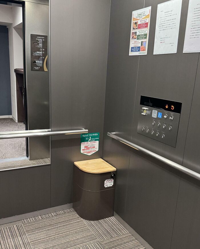 Elevator in Japan featuring an emergency seat and informational signs on the wall, showcasing Interesting-Japan-Pics.