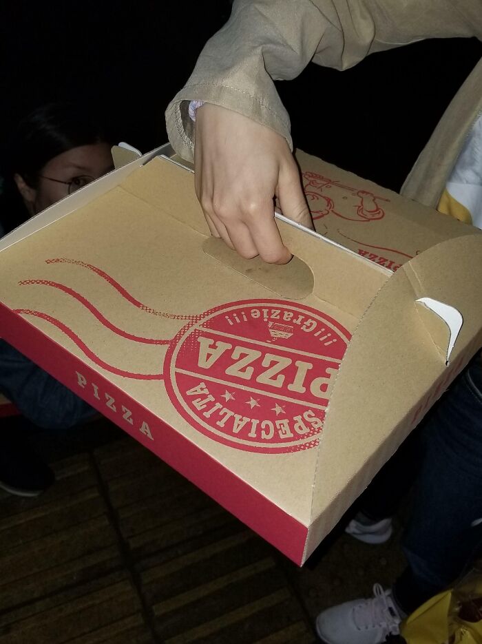 Person holding a pizza box, an interesting Japan pic showcasing local food packaging design.