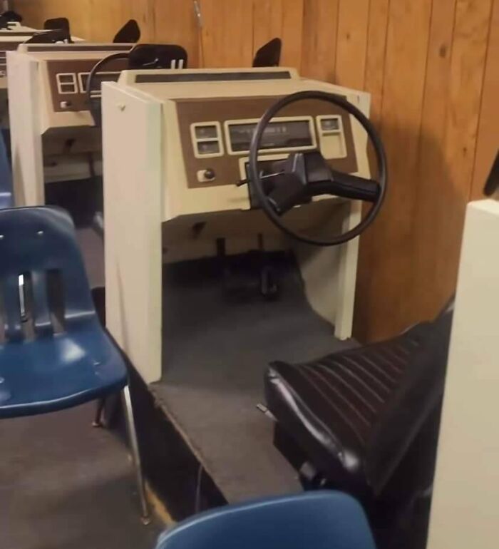 Old-school driving simulator evokes memories with vintage steering wheel and controls in a wood-paneled room.