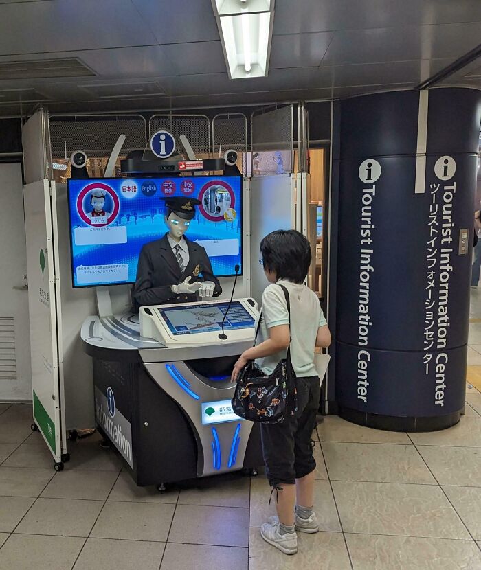 A child interacting with a robot at a Tourist Information Center in Japan, showcasing interesting Japan pics.