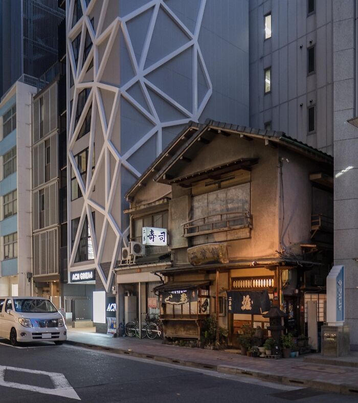Traditional Japanese building juxtaposed with modern architecture in an urban setting, showcasing interesting Japan pics.