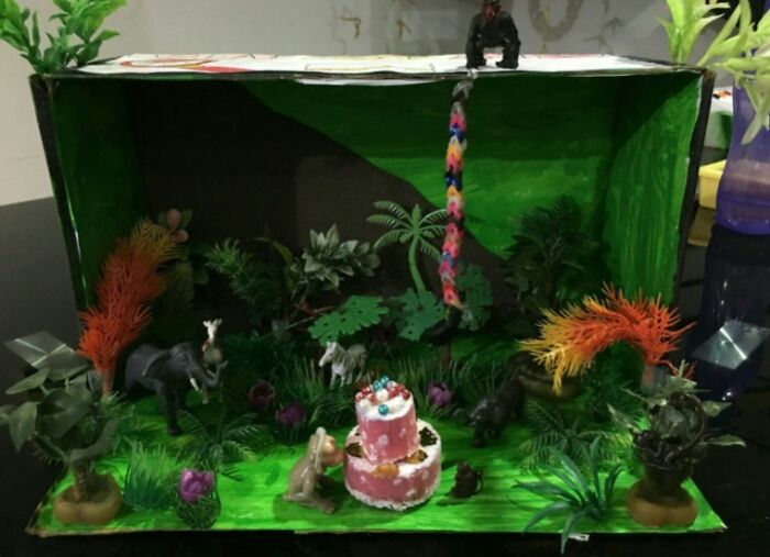Old-school items memories with a jungle diorama featuring toy animals, a pink cake centerpiece, and a colorful rope swing.