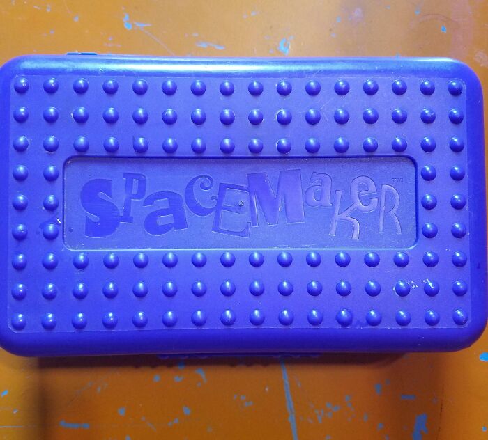 Purple Spacemaker pencil box on an orange surface, evoking old-school memories.