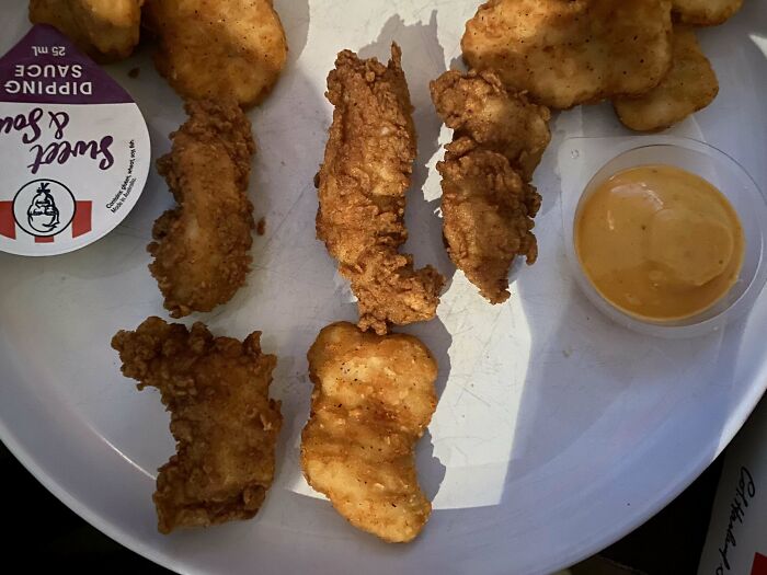 Fried chicken pieces and dipping sauces on a white plate, shared by an Australian community.