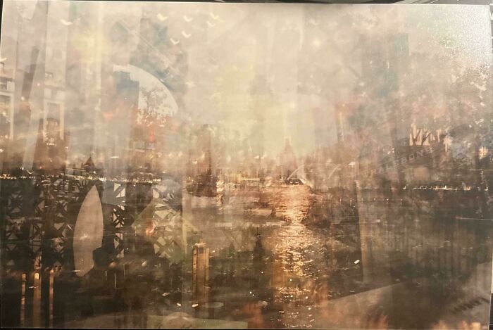 A mildly interesting abstract image with layered cityscape reflections and a glowing river at sunset.